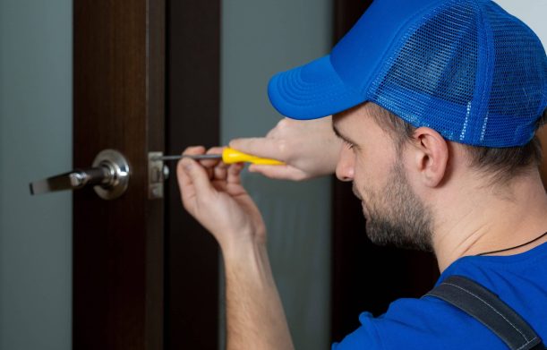 Handyman repair the door lock in the room. Closeup of man repairing the doorknob
